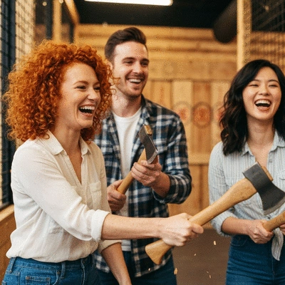 Friends laughing and enjoying axe throwing at a social gathering